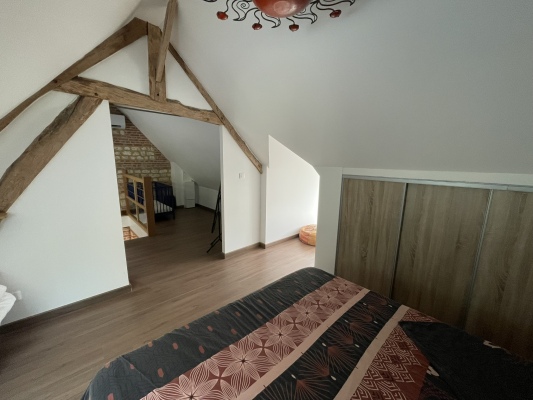 Chambre mansardée de caractère avec charpente apparente